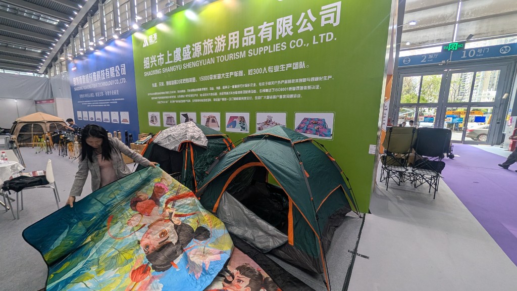 团队在深圳户外展会现场查看帐篷样品。
